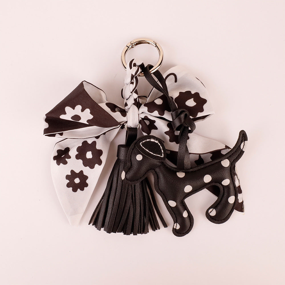 Handmade monochrome silk bow charm close up detail on brass clasp