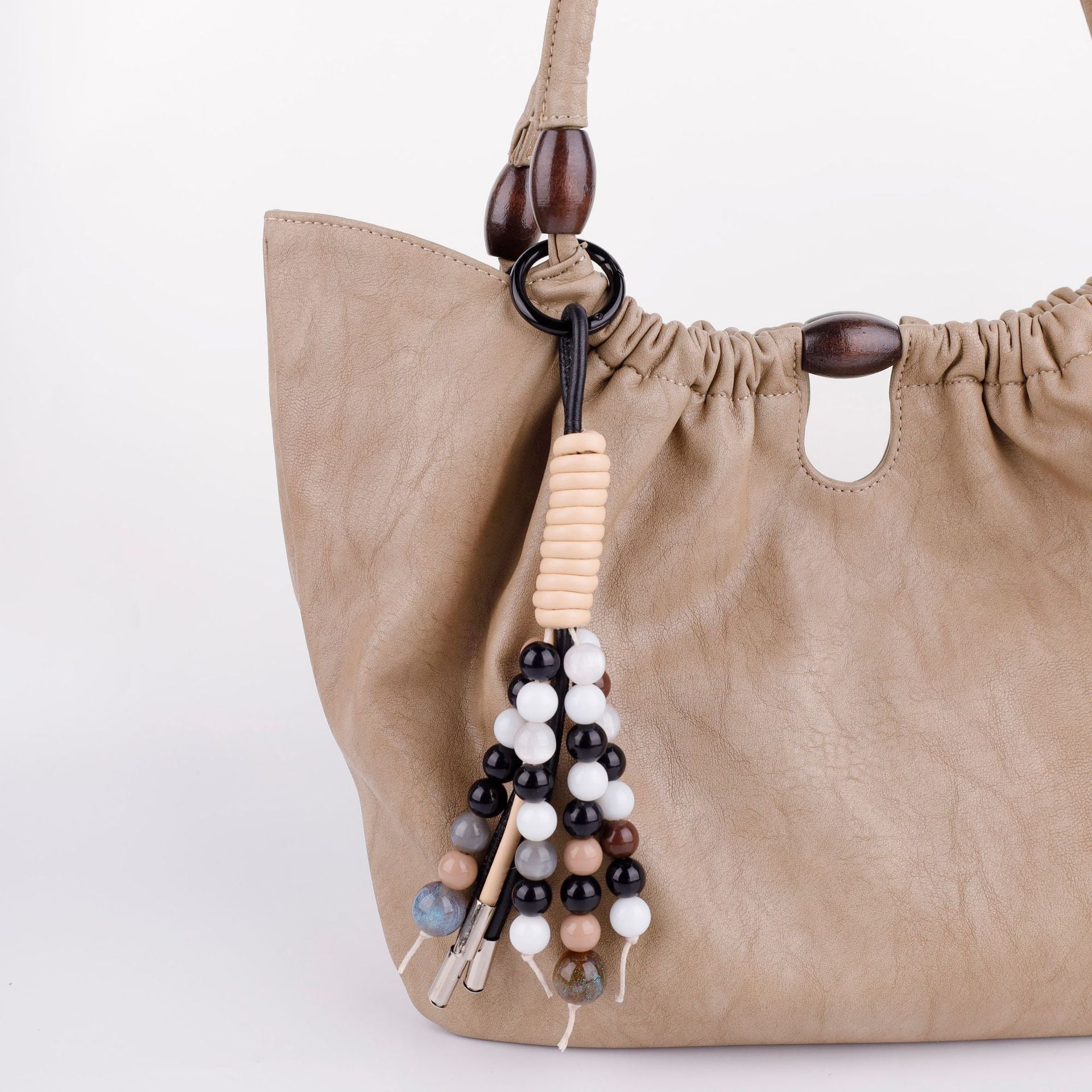 Aesthetic boho gemstone keychain and bag accessory displayed on a clean wooden tabletop