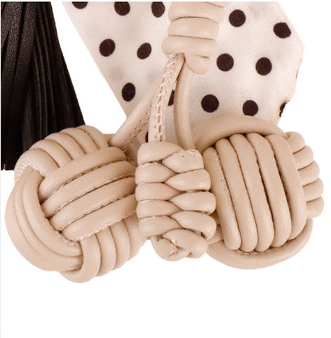 Handcrafted bow tassel clip attached to a compact daily commute purse