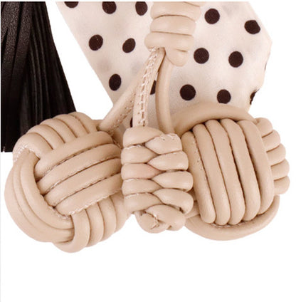 Handcrafted bow tassel clip attached to a compact daily commute purse