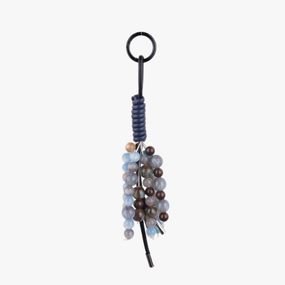 Aesthetic purple natural stone bag charm attached to a canvas tote bag