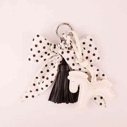 Pocket size ribbon bag decoration next to daily lipstick and key items