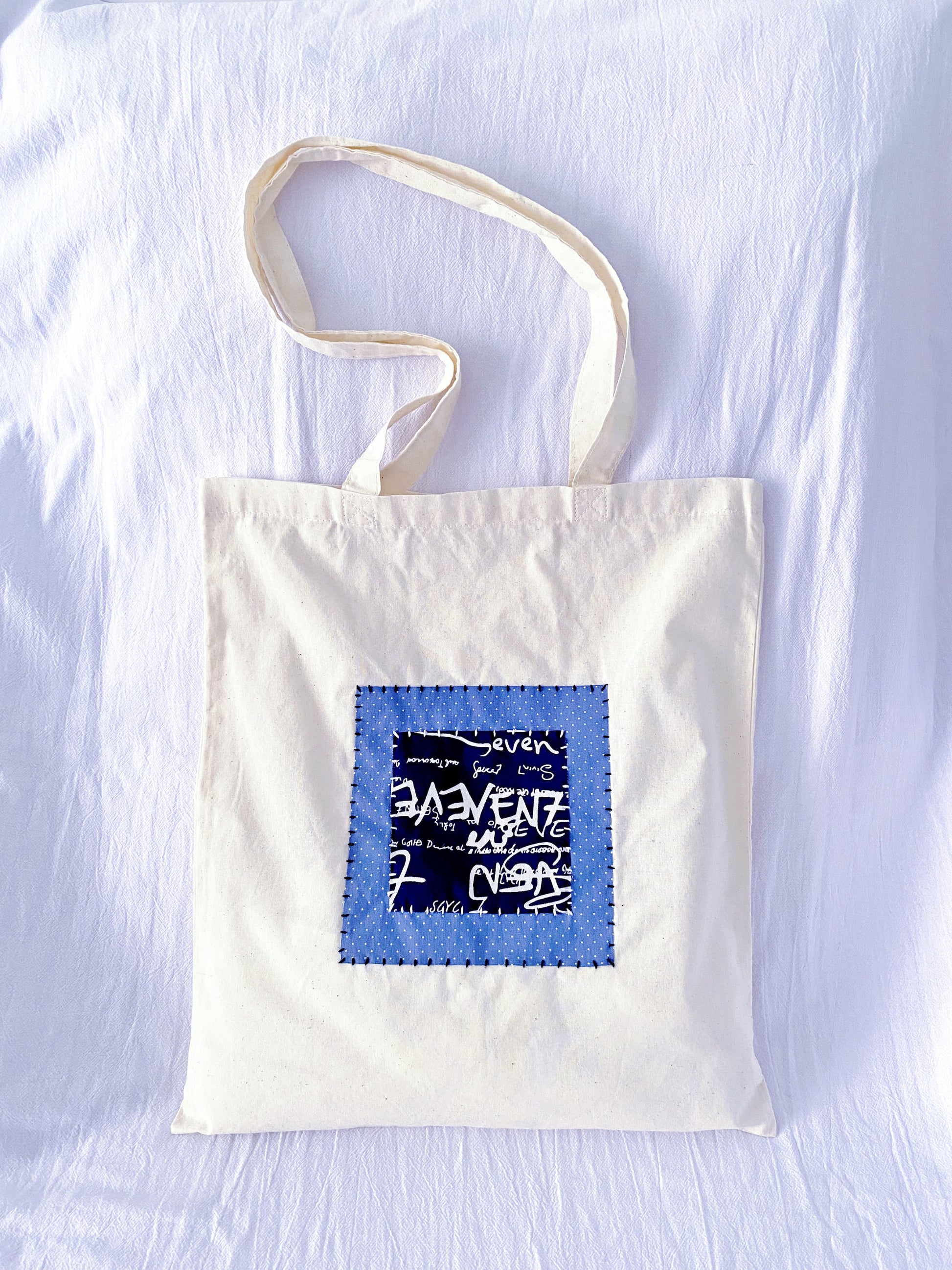 Reusable cotton tote with stitched textile panels, the kind of bag people keep reaching for when plastic feels unnecessary
