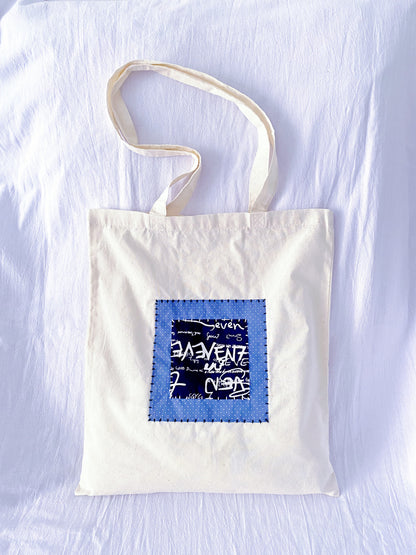 Reusable cotton tote with stitched textile panels, the kind of bag people keep reaching for when plastic feels unnecessary
