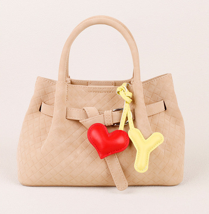Small leather heart hanging from a handbag handle