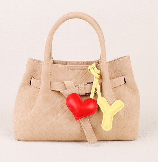 Small leather heart hanging from a handbag handle