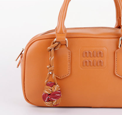 Colorful handmade bag accessory with braided cord