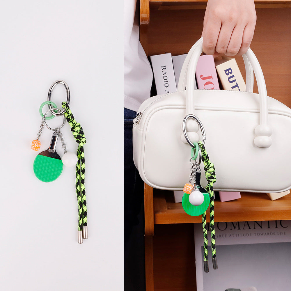Sporty charm detail on a neutral everyday handbag