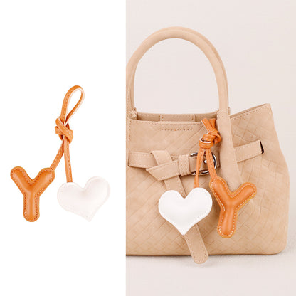 Cute stuffed leather pendant beside a bag handle