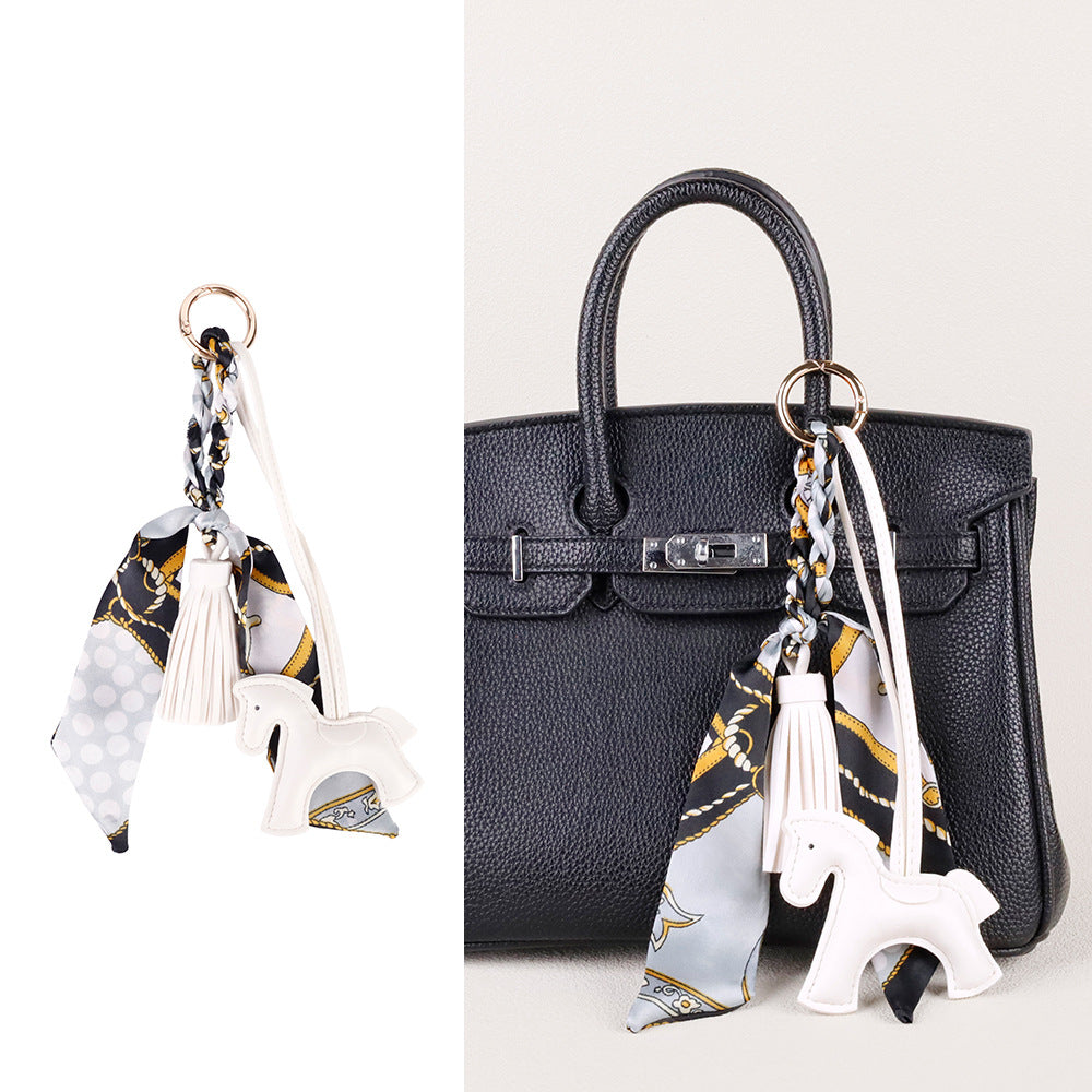 Scarf-wrapped horse charm with a soft tassel finish