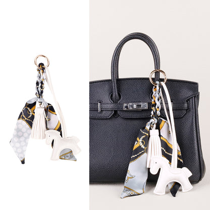 Scarf-wrapped horse charm with a soft tassel finish