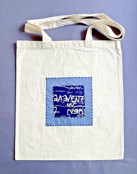 Neutral beige cotton tote bag with handcrafted patchwork detail.