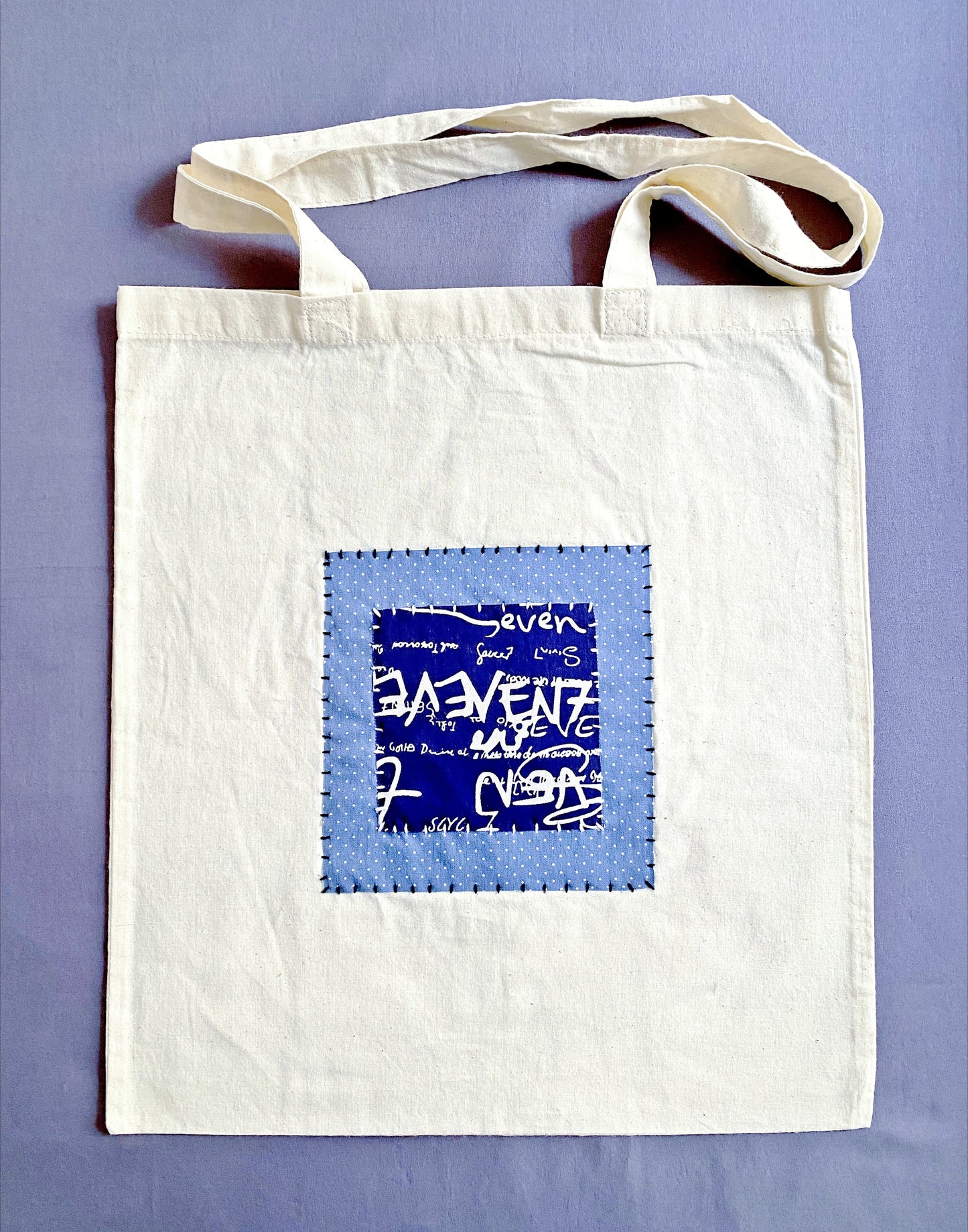 Neutral beige cotton tote bag with handcrafted patchwork detail.