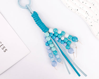 Artisanal soft purple stone charm on a backpack zipper handle