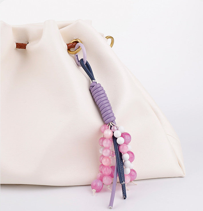 Purple crystal phone charm wristlet attached to a minimal phone case