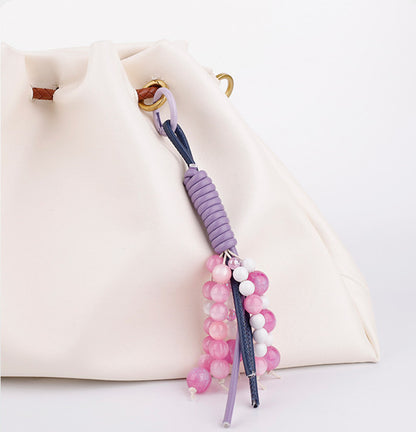 Purple crystal phone charm wristlet attached to a minimal phone case