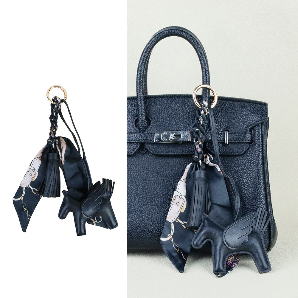 Custom stitched horse accessory attached to a zippered handbag closure pull