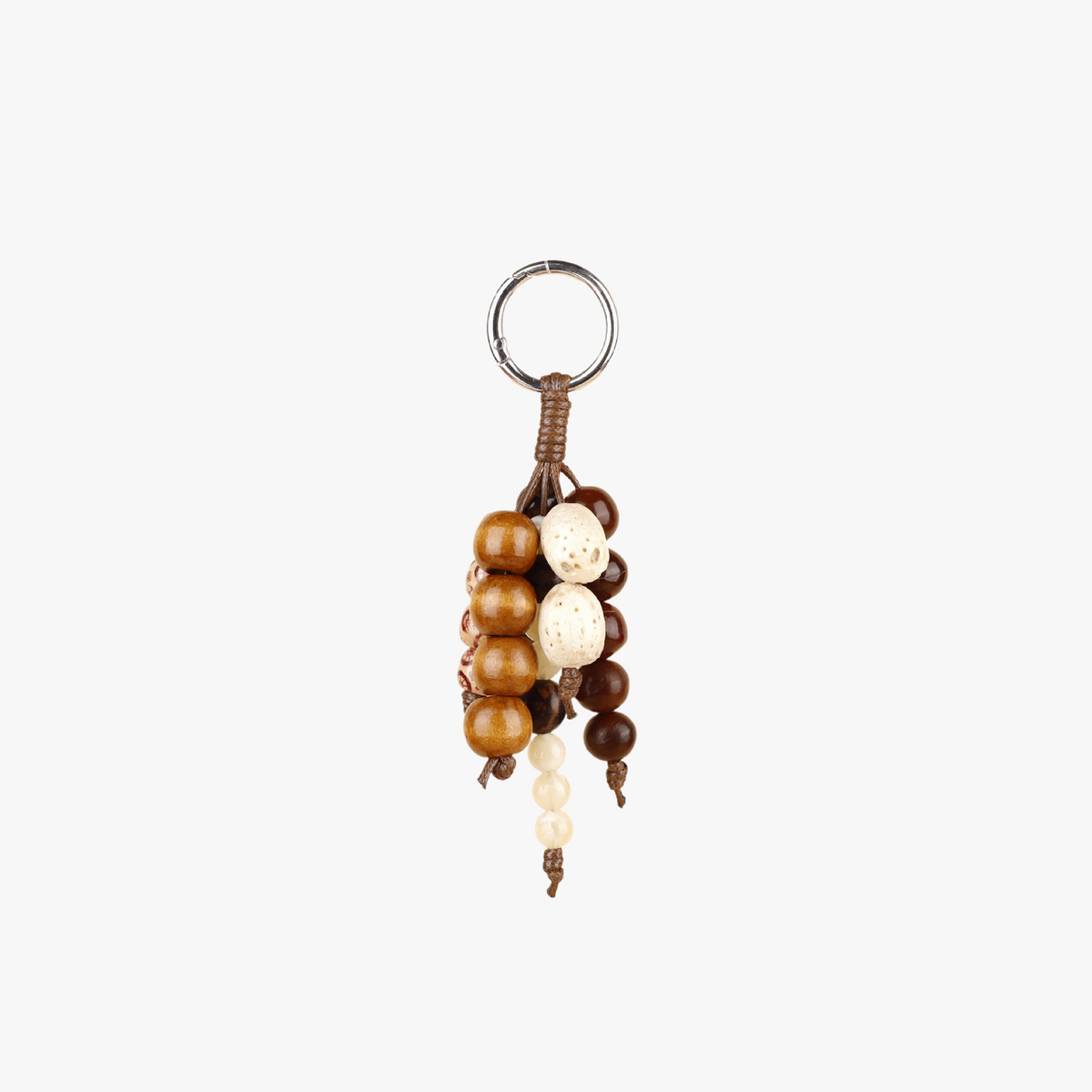 Vintage seed strand charm hanging from a handbag