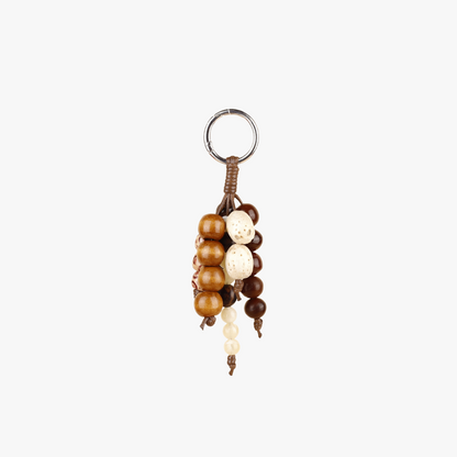 Vintage seed strand charm hanging from a handbag