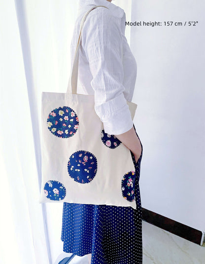 Spacious natural canvas shopper bag with colorful patchwork details that fits laptops and books for university days.