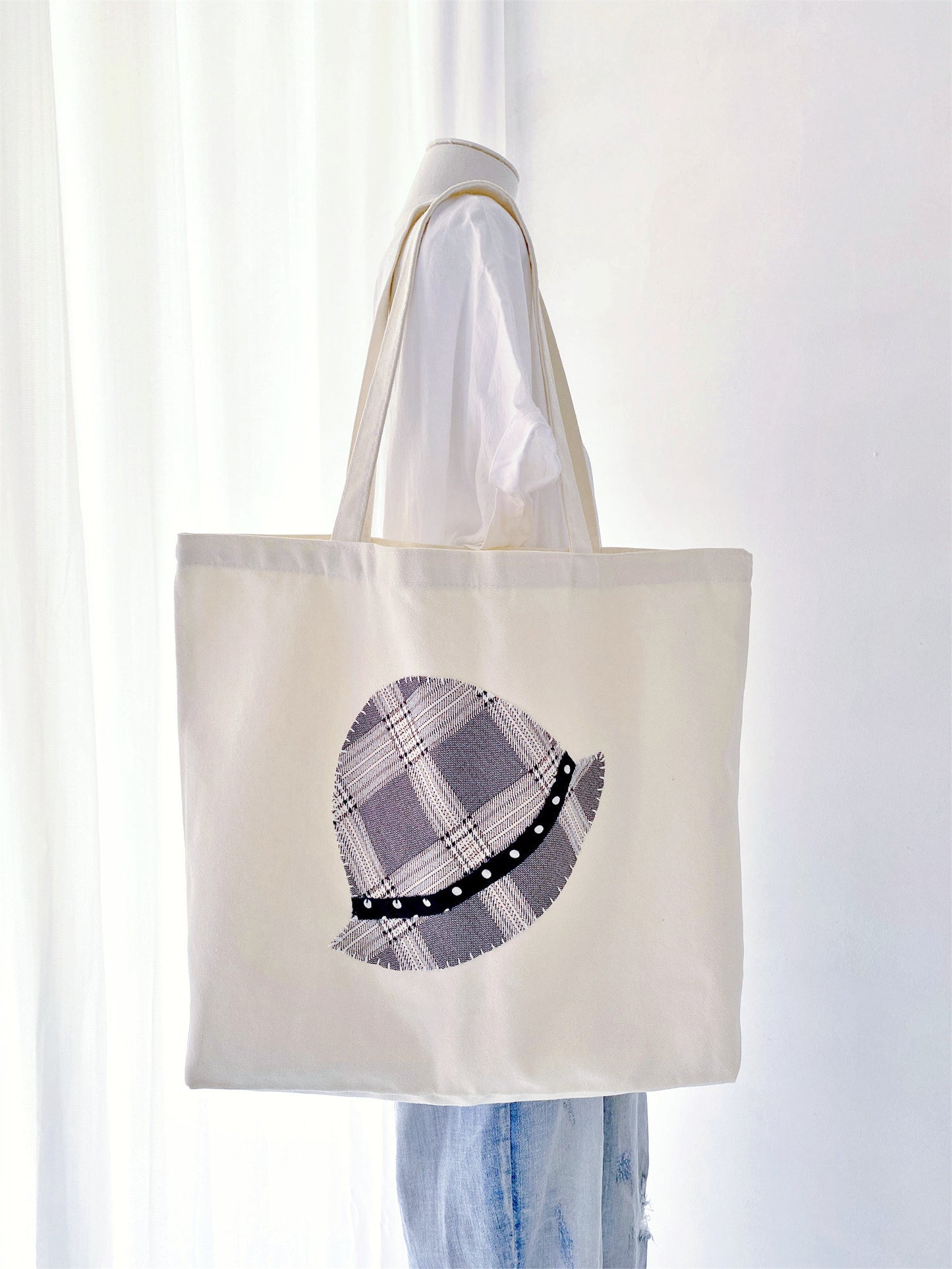 Durable oversized tote featuring handcrafted textile art. Perfectly balances modern utility with a warm, personal human touch.