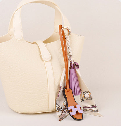 Scarf tassel charm attached to a women's tote
