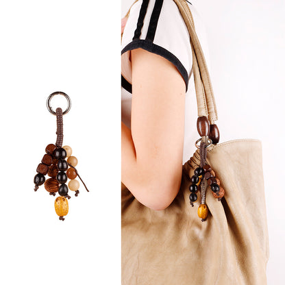 Shell and wooden bead charm clipped to a backpack strap