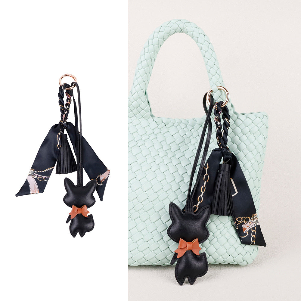 Scarf and tassel details shown against a plain backpack