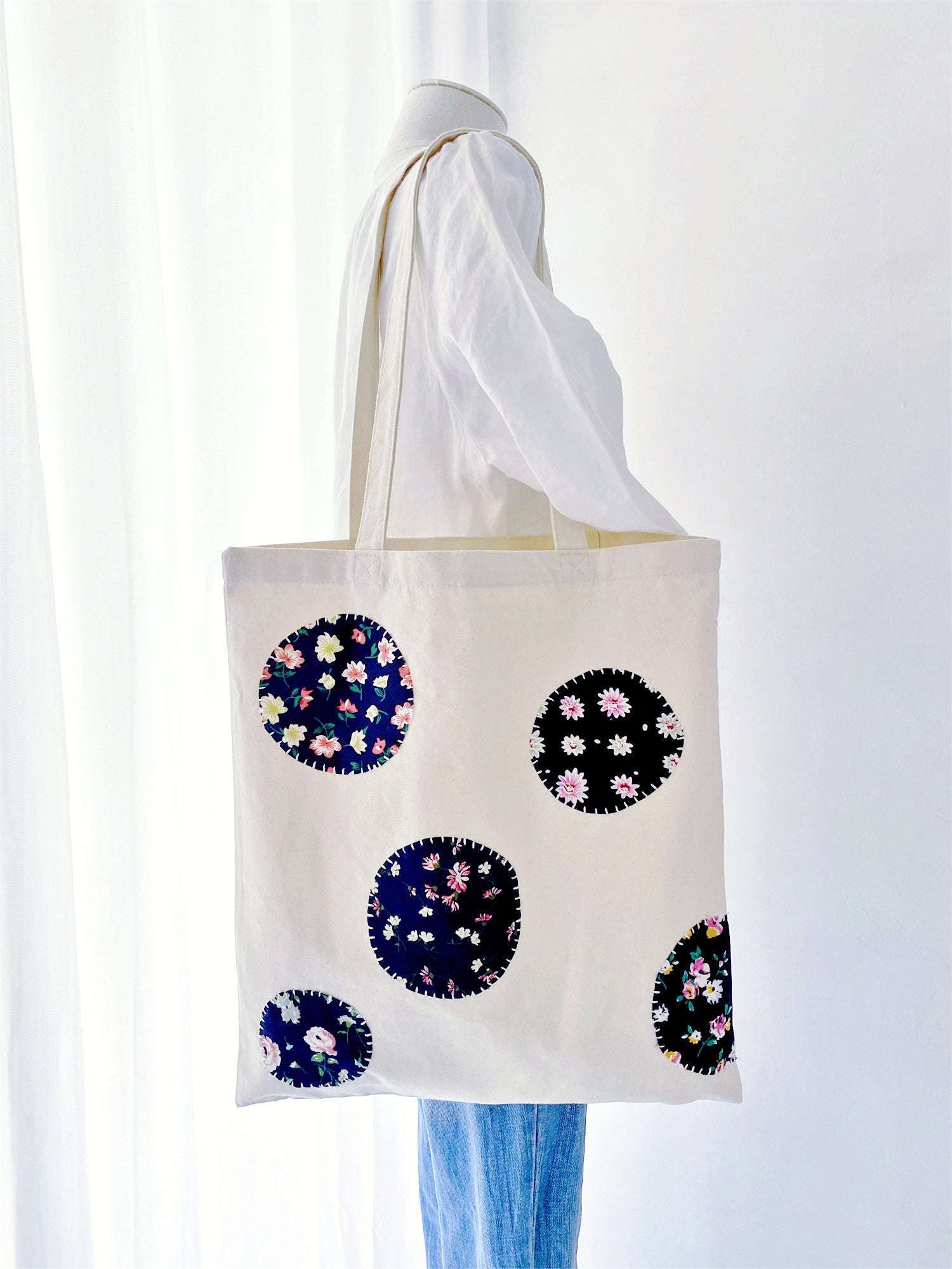 Durable weekend travel tote made from sustainable materials highlighting artistic hand-stitched fabric designs.