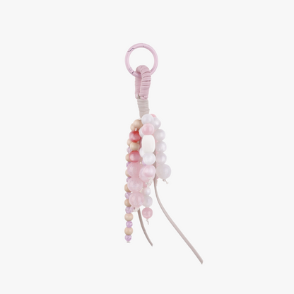 Pink natural jade bead charm hanging from a handbag