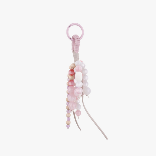 Pink natural jade bead charm hanging from a handbag