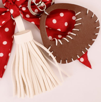 Red scarf bow accessory hanging from a women's handbag