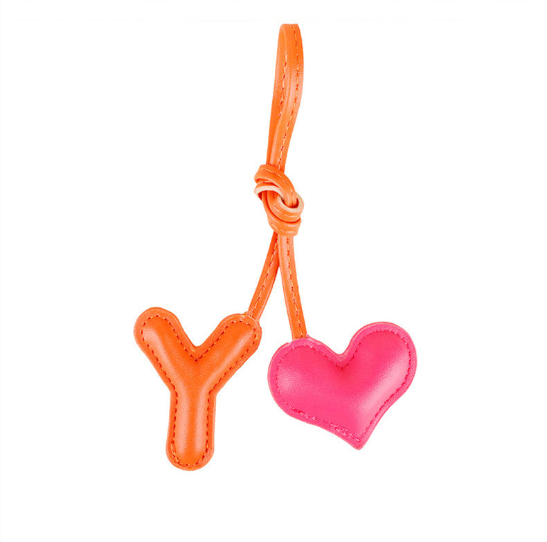 Tiny plush heart hanging beside a bag strap