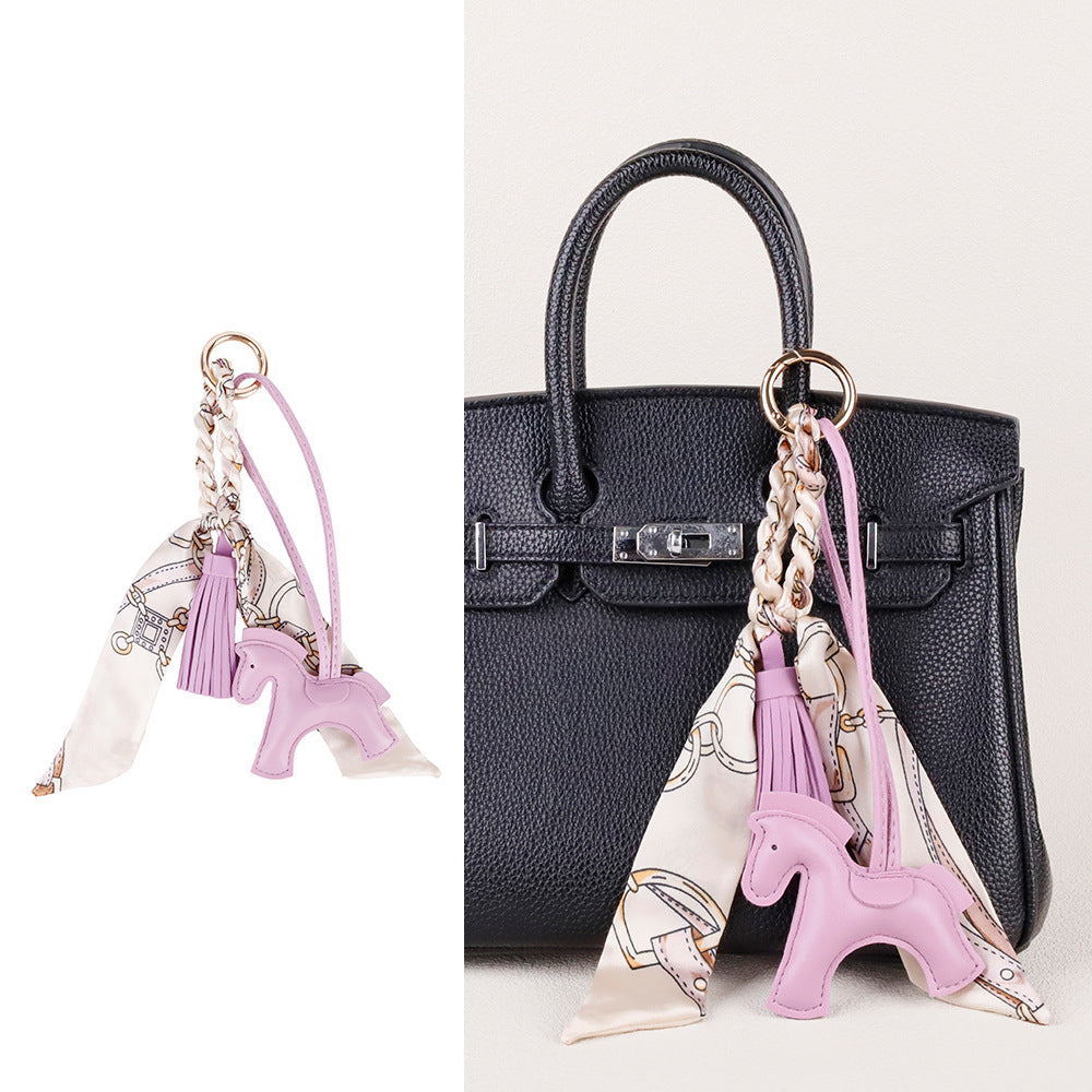 Horse charm suspended from a car rearview mirror