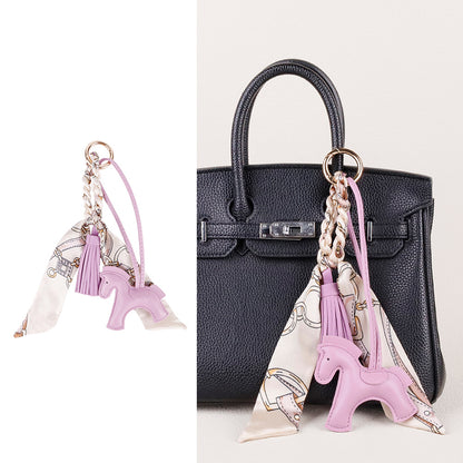 Horse charm suspended from a car rearview mirror