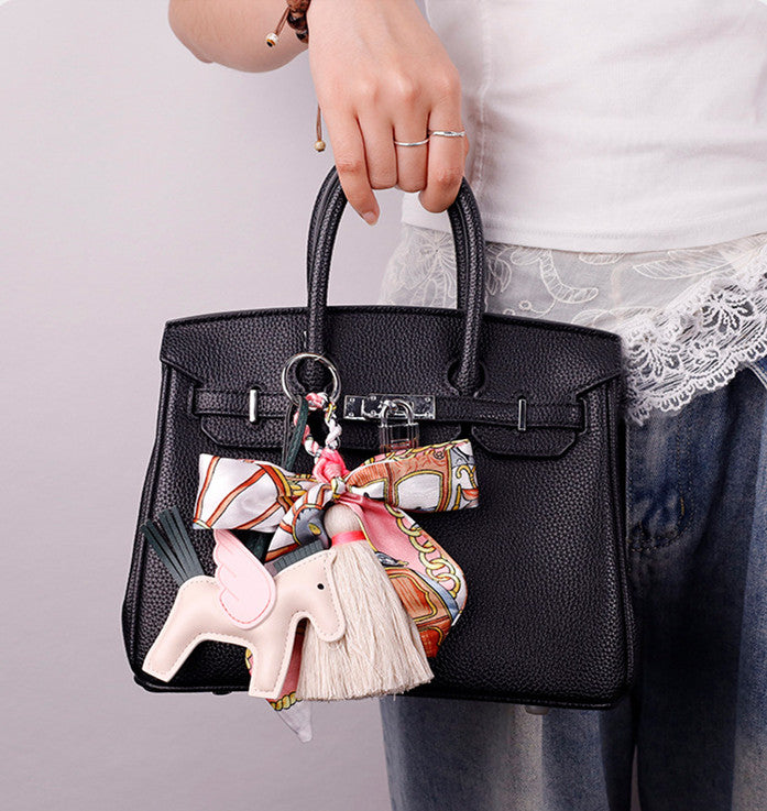 Cute horse accessory clipped onto a women's handbag