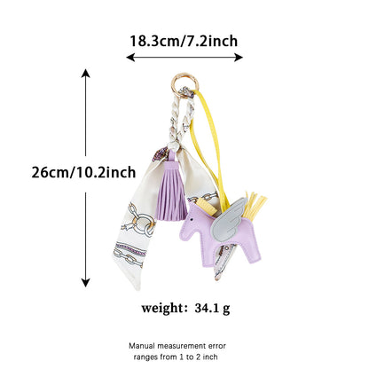 Horse shaped bag charm with silk tassel detail displayed on a structured leather tote