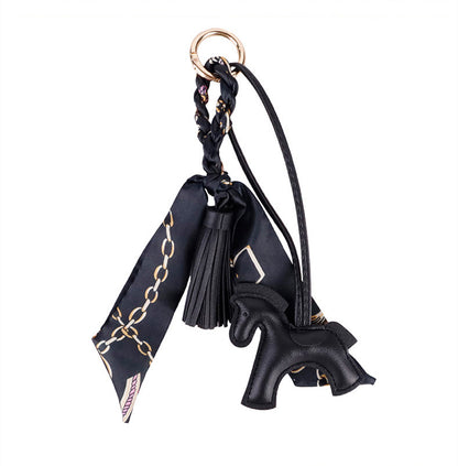 Decorative horse charm adding color to a neutral handbag