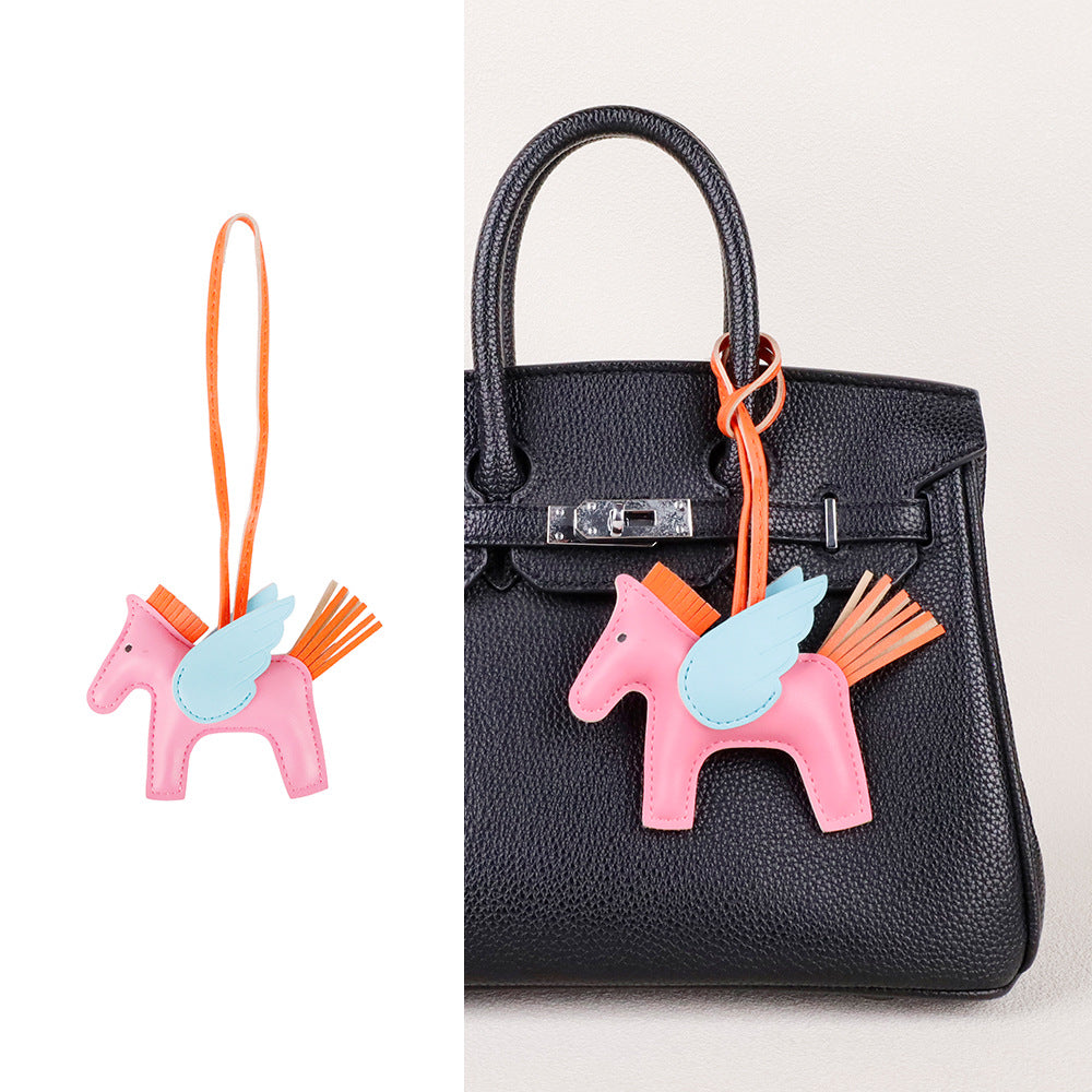 Faux leather horse tassel accessory adding texture to a woven summer tote bag