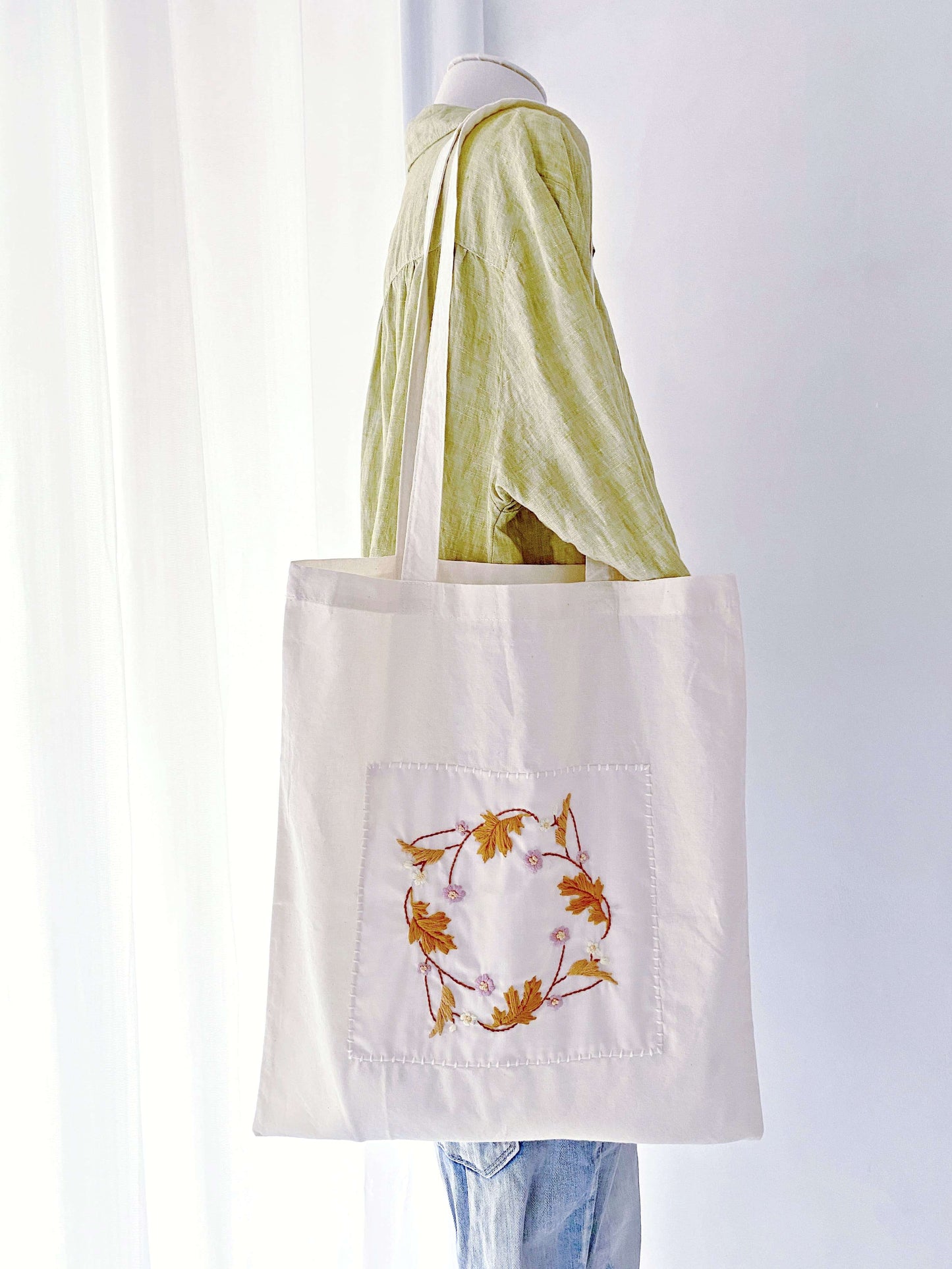 Spacious and durable cotton tote bag with floral embroidery, ideal for carrying everything sustainably.