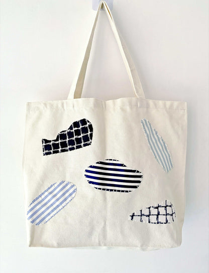 Carry bag shown holding notebooks, headphones, and a folded scarf