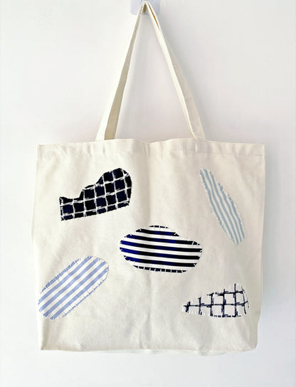 Carry bag shown holding notebooks, headphones, and a folded scarf