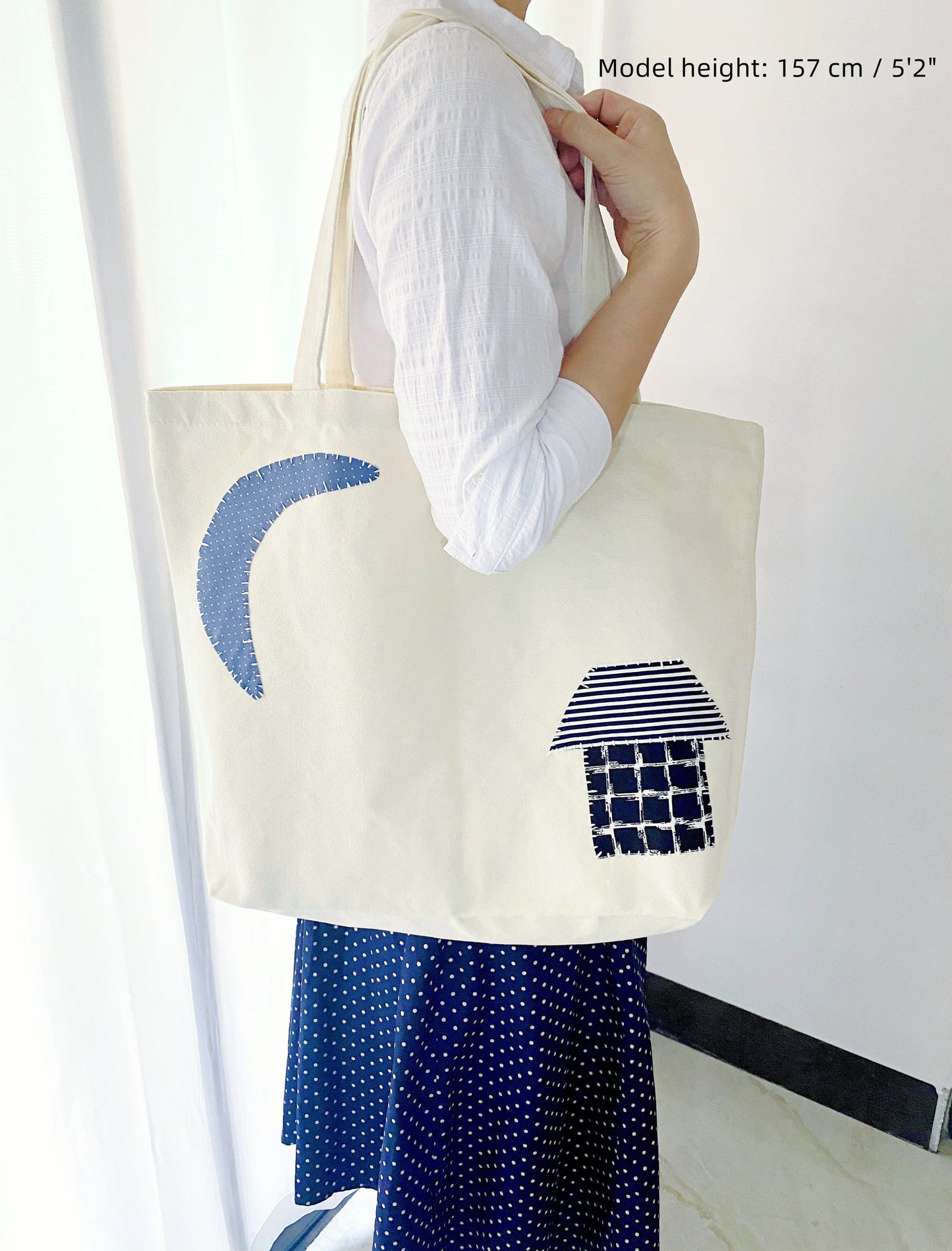 Large fabric bag shown holding books, groceries, and personal items