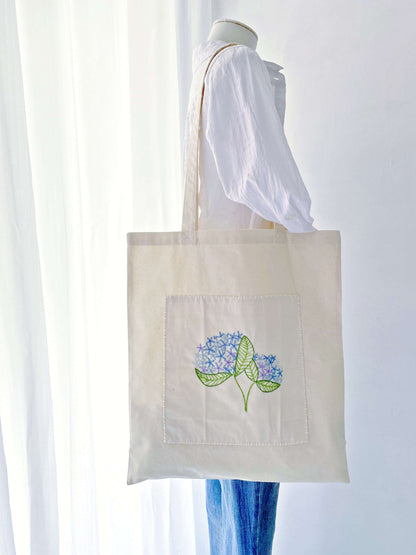 A sentimental gift for mom featuring delicate hand-stitched blooms on a super soft sustainable bag she will cherish daily.