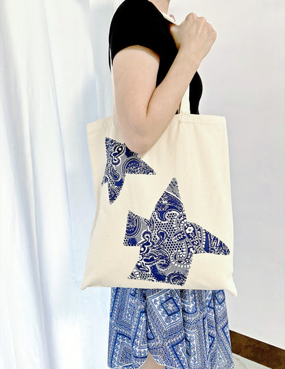 Bohemian-inspired canvas tote resting on a cafe chair, representing slow living.