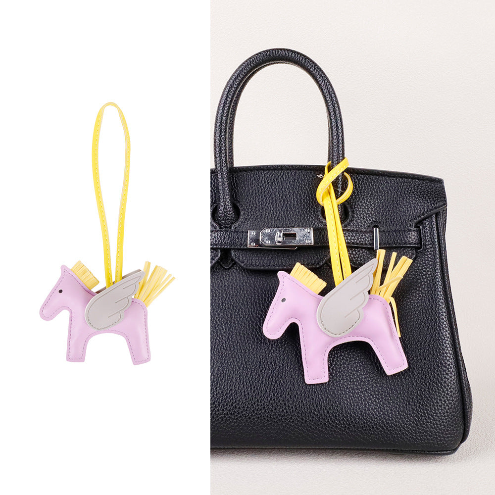Premium bag accessory clip showing horse silhouette and detailed tassel embellishments