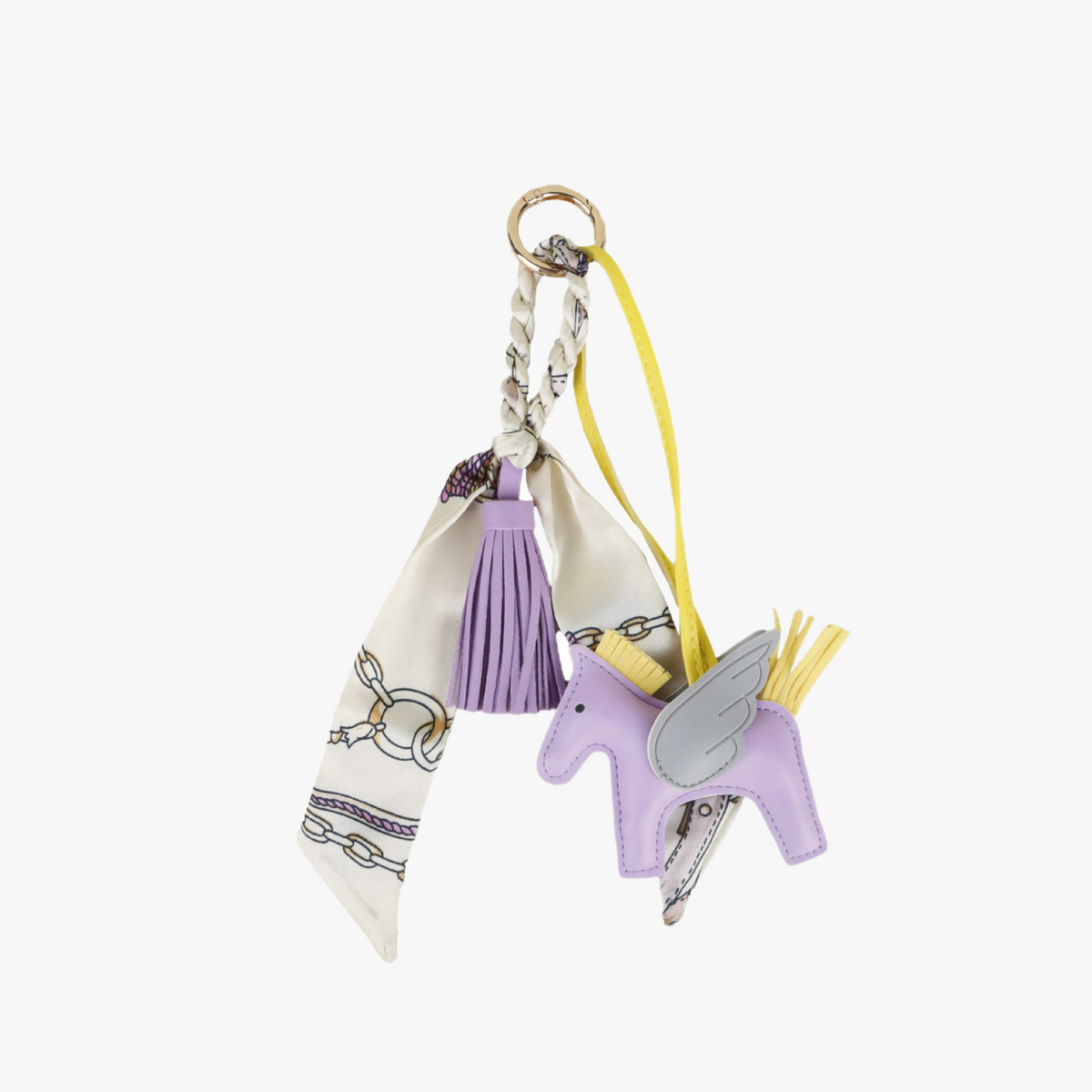 Handcrafted faux leather horse charm with silk tassel details hanging from a designer tote bag handle