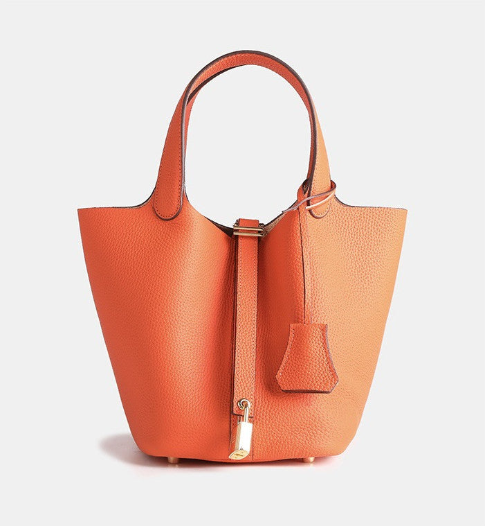 versatile small leather bucket bag worn as a shoulder handbag