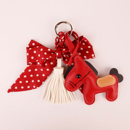 Red scarf-style bow keychain with hanging tassel accents