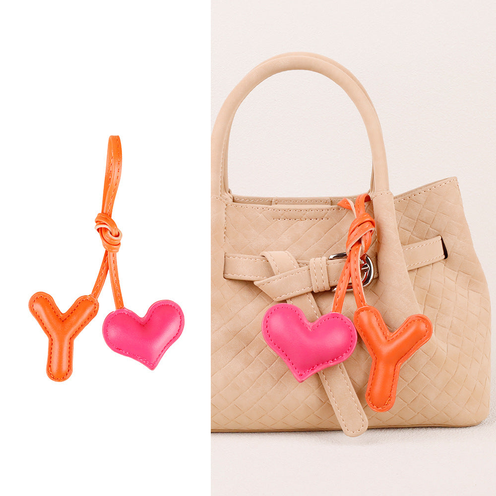 Plush heart ornament adding a playful touch to a purse